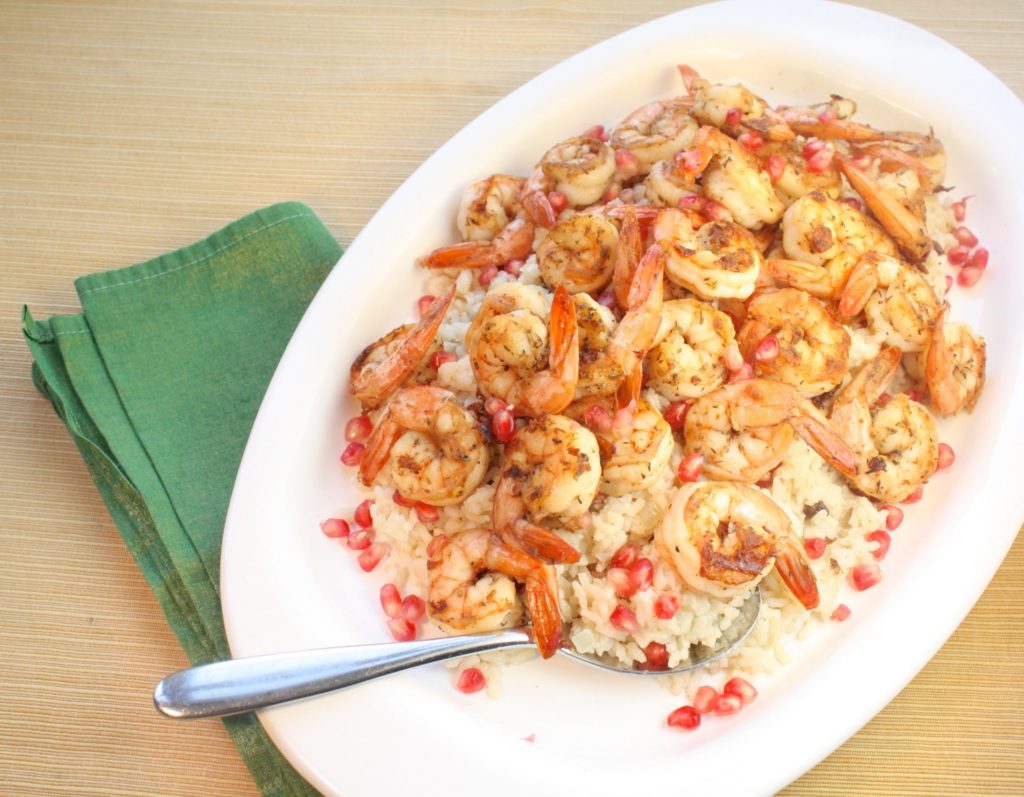 Serving spicy foods, like this Jerk Shrimp with Coconut Rice & Pomegranate, with something mild is a great way to temper the spice. Spicy Indian curries are garnished with yogurt sauces to cool down your tastebuds and this creamy, rice simmered in coconut milk with a hint of lime is the perfect counterpoint to the jerk spice. Pomegranate arils, stirred in at the end, add a dash of tartness and crunch. Together, the jerk shrimp, coconut milk and pomegranate create a perfect storm of deliciousness on your plate.