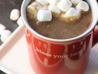 Coconut Kahlua Hot Chocolate in a red mug on a white saucer with tons of mini marshmallows