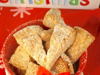 Eggnog Spiced Shortbread wedges tucked into a red bowl with a red bow.